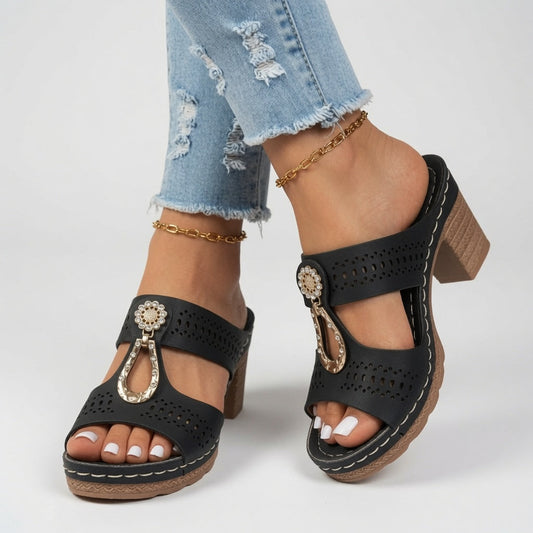 Jourdane™ — Zapatilla de tacón grueso, punta abierta, detalles decorativos y hebilla.